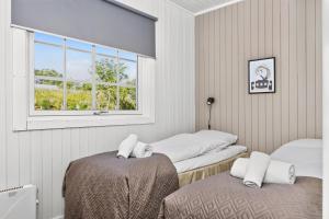 a room with two beds and a window at Astra Village - Waterfront Rorbu Cabins in Lofoten in Kabelvåg