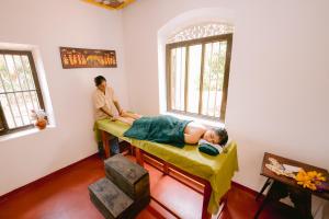 a man laying on a bed in a room at Ayu Ayuruveda Villa in Ittapana