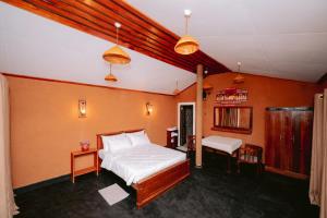 a bedroom with a bed and a table and a bench at Ayu Ayuruveda Villa in Ittapana