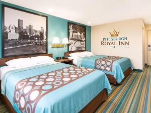 a hotel room with two beds and a sign at Pittsburgh Royal Hotel in Moon Township +3 photos