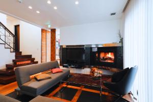 a living room with a couch and a fireplace at Danro no Yado Concept House Hoshida in Katano