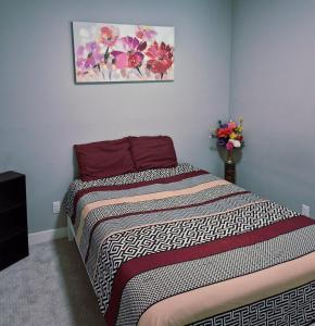 a bed in a room with a picture on the wall at Spacious Private Suite Minutes Away from Ocean,Trails and Stores in Langford