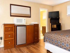 a bedroom with a bed and a microwave on a dresser at Beachway Motel in Salisbury