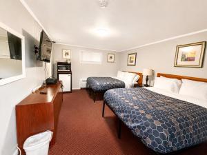a hotel room with two beds and a desk at Beachway Motel in Salisbury
