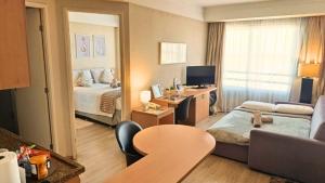 a hotel room with a bedroom with a bed and a desk at Hotel aeroporto Guarulhos in Guarulhos