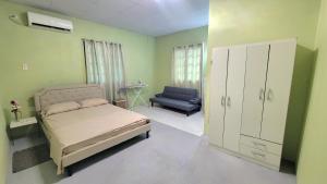 ein Schlafzimmer mit einem Bett, einem Schrank und einem Stuhl in der Unterkunft Tranquil Escape in Arima