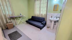 ein Badezimmer mit einer blauen Couch und einem Waschbecken in der Unterkunft Tranquil Escape in Arima + 12 Fotos