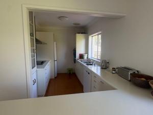 a kitchen with white cabinets and a counter top at Cliff Place in Tathra