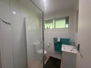 a bathroom with a toilet and a glass shower at Cliff Place in Tathra