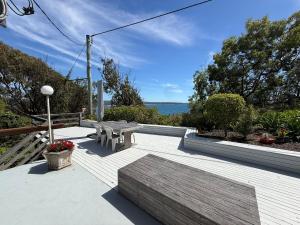 a patio with a bench and a picnic table at Cliff Place in Tathra +13 photos