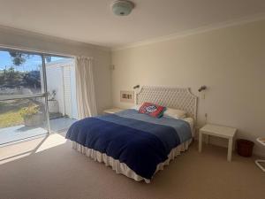 a bedroom with a bed and a large window at Cliff Place in Tathra