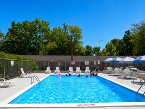 a pool with chairs and people playing in it at Beachway Motel in Salisbury