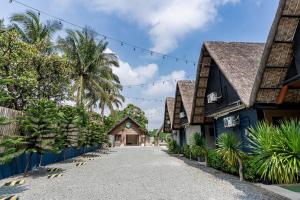 a street in front of a house with palm trees at Paragos Silvina's Cabin 2 Resort Hotel in Maitim