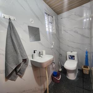 a bathroom with a sink and a toilet at Sattva Farmstay in Bangalore