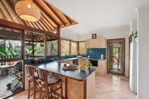 an open kitchen with a large island in a house at Riveresque - Spa Bath - Forest Views in Margaret River Town