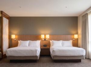 two beds in a hotel room with white pillows at BNA Suites in Nashville +12 photos