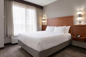 a hotel room with a large bed and a window at BNA Suites in Nashville