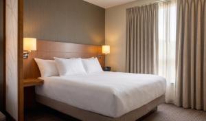 a hotel room with a large bed and a window at BNA Suites in Nashville