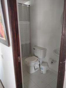 a small bathroom with a toilet and a sink at Oasis Santafe in Santa Fe de Antioquia