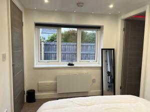 a bedroom with a white bed and a window at The Annex EV 10 per night in Southport