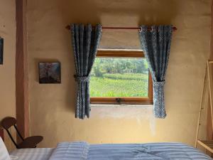 a bedroom with a bed and a window with curtains at Lũng Cú H'Mông Homestay in Loung Co