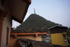 a hill with a cross on top of a building at Lũng Cú H'Mông Homestay in Loung Co +1 photo