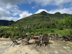a group of chairs sitting in front of a mountain at Lũng Cú H'Mông Homestay in Loung Co