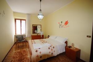 a bedroom with a large bed and a chandelier at I due cipressi in Cagli