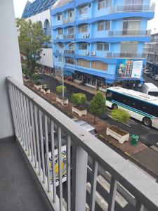 a balcony with a blue building and a bus at SWEET - City center room Papeete in Papeete