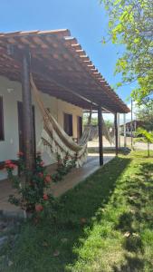 a hammock under a pergola next to a house at Chalé Renilton Turismo in Santo Amaro
