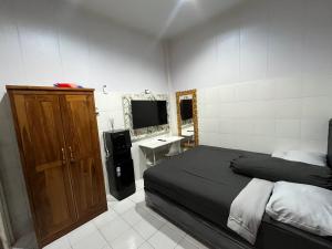 a bedroom with a bed and a television in it at Santru home in Denpasar