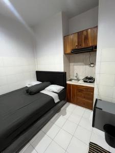 a small bedroom with a bed and a sink at Santru home in Denpasar