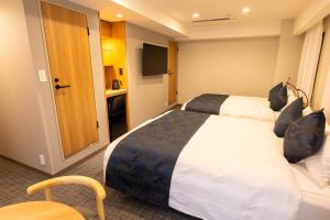 a hotel room with two beds and a television at Marroad Inn Akasaka in Tokyo +37 photos