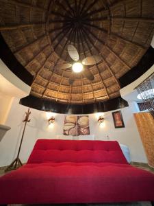 a red couch in a room with a ceiling at Cocos Cabañas Playa del Carmen Adults Only in Playa del Carmen