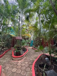 a garden with palm trees and a stone patio at Cocos Cabañas Playa del Carmen Adults Only in Playa del Carmen