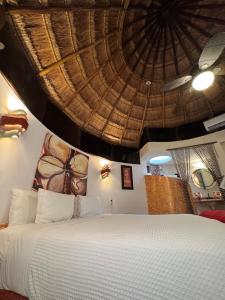 a bedroom with a large bed with a large ceiling at Cocos Cabañas Playa del Carmen Adults Only in Playa del Carmen