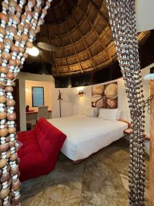 a bedroom with a large bed and a red couch at Cocos Cabañas Playa del Carmen Adults Only in Playa del Carmen +31 photos