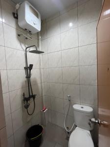 a bathroom with a toilet and a shower at Santru home in Denpasar