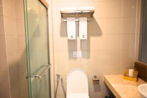 a bathroom with a toilet and a glass shower at Greenmont Hotel & Apartment in Bandar Seri Begawan +17 photos
