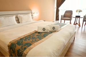 a bedroom with a large bed with two pillows on it at Greenmont Hotel & Apartment in Bandar Seri Begawan