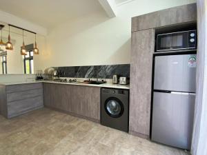 a kitchen with a refrigerator and a washer and dryer at Villa Oleemun Rezabeen - Mont Choisy in Mont Choisy
