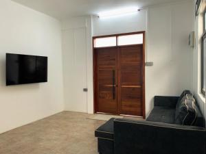 a living room with a couch and a television at Villa Oleemun Rezabeen - Mont Choisy in Mont Choisy