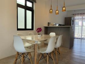 a dining room with a table and white chairs at Villa Oleemun Rezabeen - Mont Choisy in Mont Choisy +15 photos