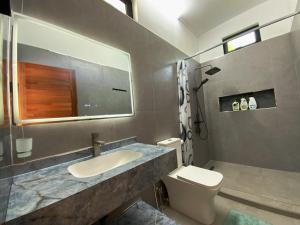 a bathroom with a sink and a toilet at Villa Oleemun Rezabeen - Mont Choisy in Mont Choisy
