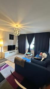 a living room with a blue couch and a chandelier at kenneth's Home in Stockholm