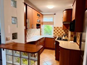 a large kitchen with wooden cabinets and a window at Robotnicza 59 Old Town Apartment in Elblag