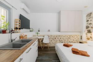 a kitchen with a sink and a bed in a room at Lithos Blue Agios Vasilios in Áyios Vasílios +13 photos