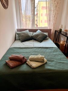 a bed with two towels on it with a window at Robotnicza 59 Old Town Apartment in Elblag