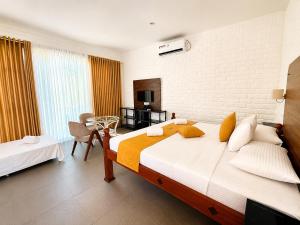 a bedroom with a large bed and a chair in it at Dutch Bay Resort & Spa in Kalpitiya