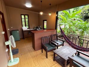 a room with a balcony with a desk and a hammock at Honey Home Pai in Pai